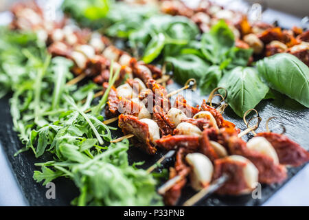 Caprese Salat mit getrockneten Tomaten Mozzarella Basilikum und Rucola auf Schiefer. Stockfoto