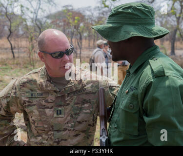 Us-Armee Kapitän Michael Wilson, 403Rd zivilen Angelegenheiten Bataillon team leader, spricht mit einem tansanischen Ranger nach einer Demonstration der Fähigkeiten Aug 24, 2016 at Rungwa Game Reserve, Tansania. Mitglieder bilden die 403Rd zivilen Angelegenheiten Bataillon, einer Komponente der Joint Task Force - Horn von Afrika und North Carolina Army National Guard, lehrte die Förster Techniken, ihre Fähigkeiten in der kleinen Einheit Taktiken, Erste Hilfe zu erhöhen, sammeln die Intelligenz und andere Bereich Kunsthandwerk. Die Soldaten waren die Rangers in der Wilderer auf der Reserve bekämpfen. Die Wilderei und den illegalen Handel mit Wildtieren hat ein so werden Stockfoto