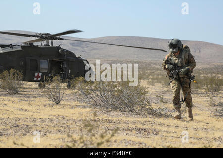 Ein Soldat der US-Armee auf das erste Bataillon zugeordnet, 8 Infanterie Regiment, 3. Brigade Combat Team, 4 Infanterie Division, verlässt eine UH-60 Blackhawk Hubschrauber Sicherheit während der entscheidenden Aktion Rotation 16-09 am National Training Center in Fort Irwin, Calif., Aug 28., 2016. (U.S. Armee Foto von SPC. JD Sacharok, Operations, National Training Center) Stockfoto