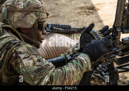 Spc. Kasheem Hamilton, eine Infanterie Soldat mit Bravo Company, 4.BATAILLON, 6 Infanterie Regiment, 3. gepanzerte Brigade Combat Team, 1. Panzerdivision, lädt eine Munition Riemen in seine Waffe während der M249/M240B Einarbeitung und Qualifizierung Ausbildung Aug.24, 2016 in Camp Arifjan, Kuwait. Die Waffe Qualifikation ist ein wesentlicher Aspekt der Soldat bereit. (U.S. Armee Foto von Sgt. Angela Lorden) Stockfoto