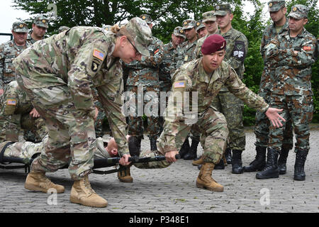 Us-Armee Sgt. 1. Klasse Sherrie Porter, vorne links, um kombinierte Waffen Training Center (CATC), 7th Army Training Befehl und die U.S. Army Staff Sgt zugeordnet. Stephen Pyon, Vordergrund rechts, 1 Geschwader zugewiesen, 91st Cavalry Regiment, 173Rd Airborne Brigade die Verwendung einer falten wurf während ein CATC bekämpfen Lebensretter Kurs auf Rose Barracks, Vilseck, Deutschland, 13. Juni 2018 zeigen. Dieser Kurs vermittelt die unmittelbare, weit nach vorn medizinische Versorgung auf einem weit verstreuten Schlachtfeld während Weitere medizinische Behandlung und Evakuierung wartet. (U.S. Armee Foto von Gertrud Zach) Stockfoto