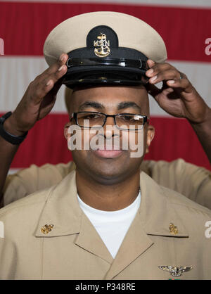 NORFOLK, Virginia (12. Juni 2018) - - Senior Chief Aviation Electronics Technician Terry West, von Columbus, Georgia, USS Gerald R. Ford's (CVN 78) Aviation intermediate maintenance Abteilung zugewiesen, wird vom Master Chief's Machinist Mate ABL Miller während eines Senior Chief Petty Officer pinning Zeremonie in den Hangar bay abgedeckt. Ford hatte 14 Chief Petty Officers in den Rang eines Senior Chief Petty Officer. (U.S. Marine Foto von Mass Communication Specialist 3. Klasse Ryan Carter) Stockfoto