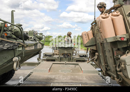 Ein Soldat der britischen Armee zu 130 English Ingenieur Bataillon zugeordnet navigiert mit der Fähre über die Memel bei einer angefochtenen nassen Spalt Kreuzung in der Nähe von Kaunas, Litauen, 13. Juni 2018. Die amphibischen Vermögen der 130 DEB zusammen mit der Erleichterung des Staging und Bewegung durch die Regimental Engineering Squadron, 2d-Cavalry Regiment für fast 200 Strykers und militärische Unterstützung Fahrzeuge erlaubt erfolgreich Kreuz, sich vorwärts zu bewegen, Kampfkraft und 2 CR-operative Reichweite erweitern. Stockfoto