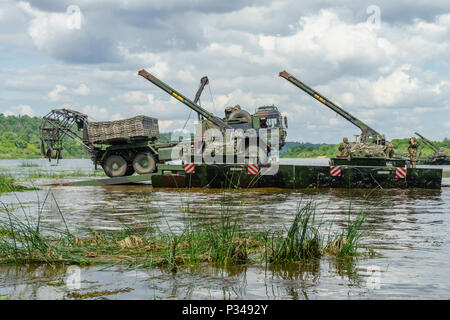 Eine deutsche Armee utility Truck bereitet eine temporäre Straße für Kampffahrzeuge zu Platz nach dem Nemen River Crossing auf einen M3 amphibischen Bridging Fahrzeug während einer multinationalen Schulungsveranstaltung in der Nähe von Kulautuva, Litauen, 23. Juni 2018 zu verwenden. Die Veranstaltung ist ein Grundpfeiler der Sabre Streik 18, eine jährliche Übung in seine achte Iteration, Teilnehmer aus 19 Ländern im Hinblick auf ihre Fähigkeit zur Zusammenarbeit und die Fähigkeit der einzelnen Einheit ihre benannten Aufgaben verbessern. (U.S. Armee Foto von Sgt. Gregory T. Sommer/22 Mobile Public Affairs Abteilung) Stockfoto