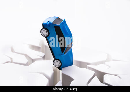 Close-up ein blaues Auto stürzte auf beschädigte Weiße Oberfläche Stockfoto