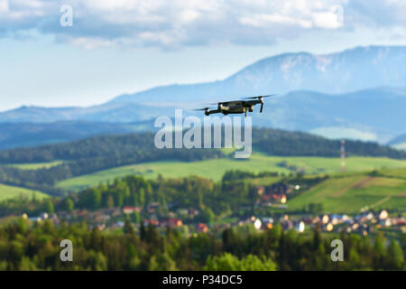 Drone mit Kamera fliegen über Berge Felder. Antenne Fotografie und Videografie. Drone quad Copter mit hochauflösenden Digitalkamera in der Luft Stockfoto