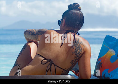 Mädchen mit Tätowierungen Sonnen in Tahiti Stockfoto