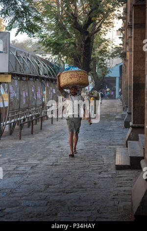 MUMBAI, INDIEN - Januar 29, 2017: unbekannter Mann carryng Gewicht auf seinem Kopf - ein Eimer voller frischer Fisch Stockfoto