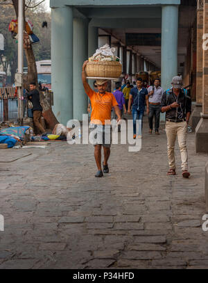 MUMBAI, INDIEN - Januar 29, 2017: unbekannter Mann carryng Gewicht auf seinem Kopf - ein Eimer voller frischer Fisch Stockfoto