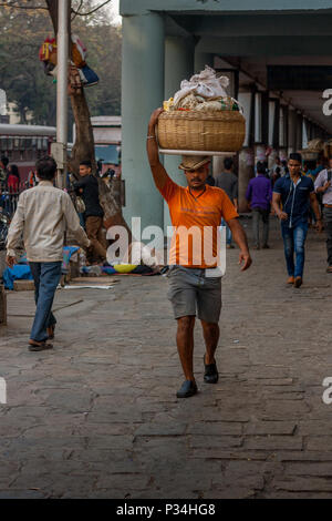 MUMBAI, INDIEN - Januar 29, 2017: unbekannter Mann carryng Gewicht auf seinem Kopf - ein Eimer voller frischer Fisch Stockfoto