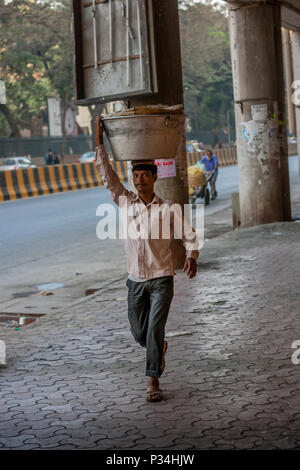 MUMBAI, INDIEN - Januar 29, 2017: unbekannter Mann carryng Gewicht auf seinem Kopf - ein Eimer voller frischer Fisch Stockfoto