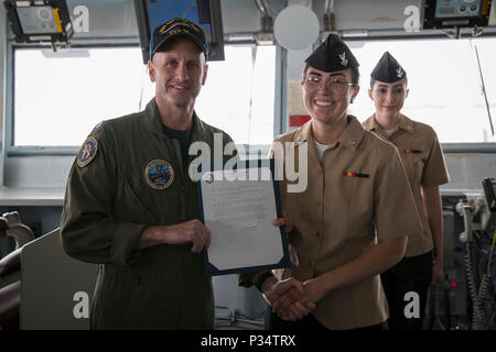 NORFOLK, Virginia (12. Juni 2018) - quartermaster 2. Klasse Zoe Tomlinson, aus Tucson, Arizona, zu USS Gerald R. Ford's (CVN 78) Navigation Abteilung zugewiesen, erhält Ihr frocking Brief von Cmdr. Jade Lepke, Navigation Ford's Officer, während der Werbeaktion Zeremonie auf der Brücke des Schiffes. (U.S. Marine Foto von Mass Communication Specialist 3. Klasse Josua Murray) Stockfoto