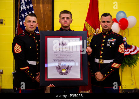 Pfc. Gavin G. Northcutt, hält die Ehrenamtlichen Marine Award (posthum) für seine Cousine Jäger A. Northcutt neben Staff Sgt. James B. Benham (links) und Gunnery Sgt. Nathan D. Mitchaner (rechts), dem lokalen Marine Corps Personalvermittler, bei Pelham Grundschule, Pelham, Tennessee, 13. Juni 2018. Hunter wurde in Zeile auf die Familie Tradition als United States Marine leider sein Terminal Leukämie endete sein Leben, bevor er auf den gelben Fußspuren stehen könnte. (U.S. Marine Corps Foto von Sgt. Mandaline Castillo) Stockfoto