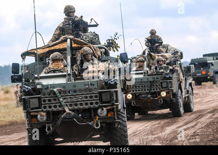 Ein Konvoi von Mobilität Weapon-Mounted Installation Kit" Schakale" mit der britischen Armee 1. Der Königin Dragoon Guards, bewegen Sie eine multinationale Schulungsveranstaltung für übung Puma 2 mit Battle Group Polen Bemowo Piskie Training Bereich zu beginnen, Polen am 14. Juni 2018 im Rahmen der Sabre Streik 18. Die diesjährige Übung, die läuft von Juni 3-15, tests Verbündete und Partner aus 19 Ländern auf ihrer Fähigkeit, arbeiten zusammen, um die Aggression in der Region zu verhindern und die Fähigkeit der einzelnen Einheit ihre benannten Mission durchführen zu verbessern. (U.S. Armee Foto von SPC. Hubert D. Delany III/22 Mobile Public Affairs Abteilung) Stockfoto