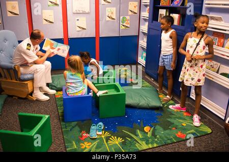 180614-N-SH 284-2106 Chattanooga, Tennessee (14. Juni 2018) Cmdr. Paul Seitz, kommandierender Offizier, USS Tennessee blauen Crew, liest für Kinder im Creative Discovery Museum während Chattanooga Marine Woche. Jedes Jahr, Amerikas Marine nach Hause kommt auf ca. 15 Städten im ganzen Land zu zeigen, warum die Amerikaner eine starke Marine entscheidend für den American Way of Life. (U.S. Marine Foto von Mass Communication Specialist 2. Klasse Vaughan Dill/Freigegeben) Stockfoto