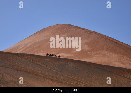 Camel Riders, Blick auf die Tian Shan, Flammenden Berge, Xinjiang, China Stockfoto