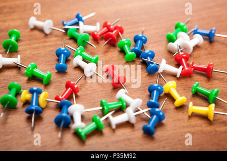 Satz von Pins in verschiedenen Farben auf einem hölzernen Hintergrund Stockfoto