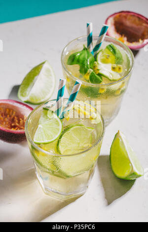 Frische Sommer Limonade mit Eis, Kalk und Passionsfrucht auf blauem Hintergrund. Stockfoto