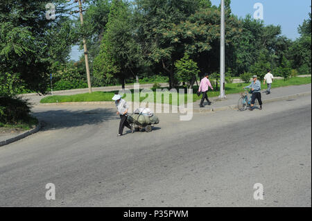 Pjoengjang, Nordkorea, Fußgänger gehen Sie eine Straße Stockfoto