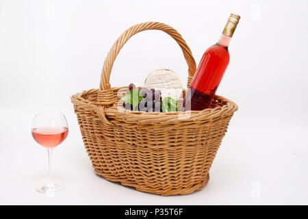 Einen Korb mit Wein trauben, Käse und eine Flasche Rotwein gefüllt Stockfoto