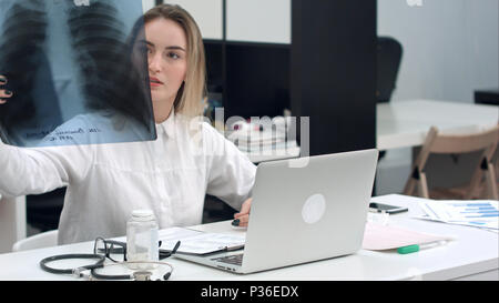 Ärztin Untersuchung röntgen Bild sitzen im Büro Stockfoto