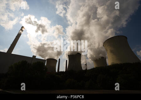 Viel Dampf aus einigen Kühltürme und ein Schornstein ist verdunkelt die Sonne. Stockfoto