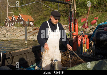 Lohme, Deutschland, ein Fischer in seinem Boot am Hafen Stockfoto