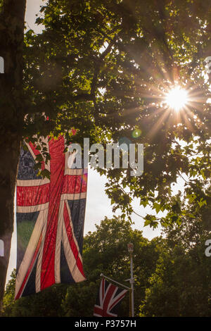 Der Union Jack von hinten beleuchtet, wie die Sonne auf der Mall in London setzt Stockfoto