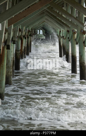 Wellen unter einem Pier am Strand in North Myrtle Beach, South Carolina Stockfoto