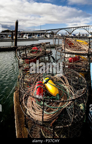 Oder 02493-00 ... OREGON - Crab Töpfe auf dem Newport Marina mit der Yaquina Bay Bridge im Hintergrund von der Stadt Newport. Stockfoto