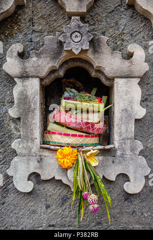 Traditionelle hinduistische Balinesen Angebote canang Sari in Stein Altar. Bali, Indonesien. Stockfoto