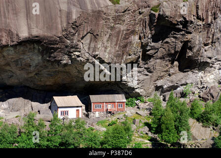 Heller, Norwegen, alte Häuser unter einem Felsvorsprung Stockfoto