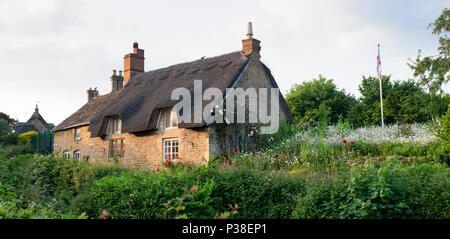 Reetdachhaus in der Abendsonne in Ebrington, Chipping Campden, Gloucestershire, England. Panoramablick Stockfoto