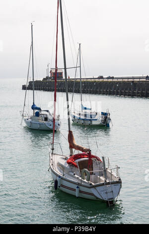 Drei segeln Yachten vor Anker in der äußeren Hafen von Folkestone, Kent, England, Großbritannien Stockfoto