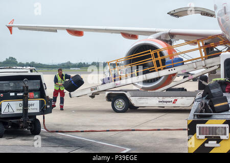 Flughafen Bristol, UK. Ein baggage handler Koffer Verladen auf ein Easyjet Flugzeug Stockfoto