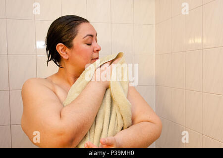 Eine Frau mit einem grünen Tuch Tücher nass Wasser ihre Haut Stockfoto