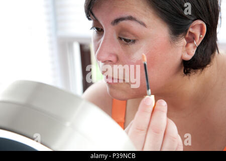Frau gilt oder Stiftung, die eine Make-up-wand Stockfoto