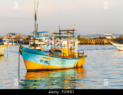 Die traditionellen lokalen Stil kleine bunte Fischerboot im malerischen Hafen in Weligama an der Südküste von Sri Lanka im Morgenlicht Stockfoto