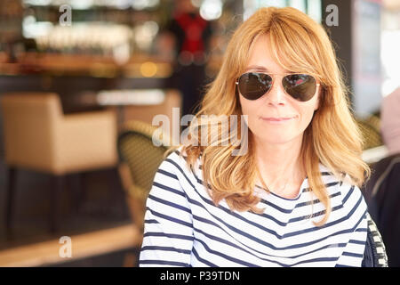 Close-up Portrait von lächelnden Frau mittleren Alters im Bistro sitzen und entspannen. Stockfoto