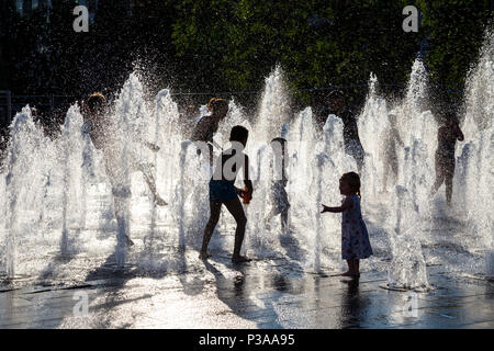 Silhouetten von Kindern, obwohl ein Brunnen im Sommer, Piccadilly, Manchester, UK Stockfoto