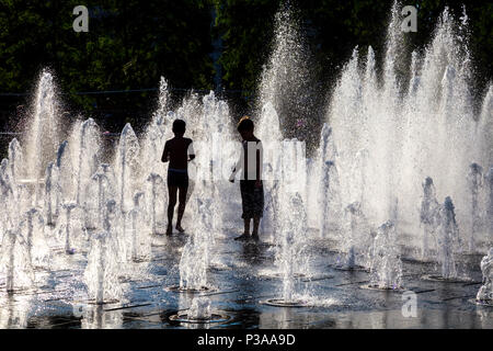 Silhouetten von Kindern, obwohl ein Brunnen im Sommer, Piccadilly, Manchester, UK Stockfoto