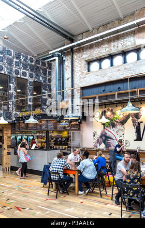 Die Menschen essen in einem Food Court, Interieur des Mackie Bürgermeister in einem ehemaligen Fleischmarkt Gebäude in Manchester, Großbritannien Stockfoto