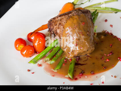 Gegrillte Rindersteaks mit Gewürzen, Tomaten und Spargel in Rosa peper Sauce Stockfoto