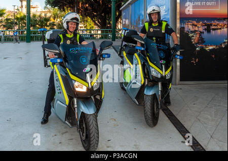 Zwei Spanische lokale Polizisten auf Streife auf neue Motorroller in Málaga, Spanien. Stockfoto