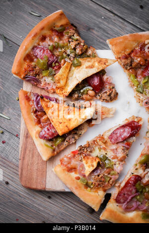 Frische italienische Pizza. Food Fotografie für Design. Mexikanische Pizza mit Pommes, Zwiebel, Hot jalapeno Pfeffer auf dünnen classic Teig. Nahaufnahme der Schicht. Stockfoto