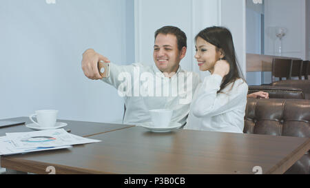 Paar Kollegen unter Lustig selfies auf dem Handy in ein Cafe Stockfoto
