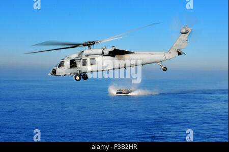 Ozean (31. 6, 2008) Einem MH-60S Knighthawk Helikopter fliegt über eine Landing Craft air cushion aus dem amphibious Transport dock Schiff USS New Orleans LPD (18). New Orleans ist auf eine Zertifizierung als Teil der Boxer Expeditionary Strike Group in Vorbereitung für eine bevorstehende Bereitstellung. Stockfoto