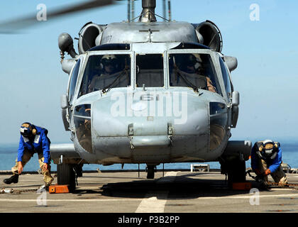 Golf (31. 11, 2008) Bootsmann Mate 3. Klasse Virginia Moratalla, Links, und Seaman Daniel Nguyen mit Unterlegkeilen sichern und die Kette einem MH-60S Hubschrauber Hubschrauber Meer Combat Squadron (HSC 26) an Bord der Amphibischen dock Landung Schiff USS Carter Hall (LSD 50). Carter Hall ist als Teil der Iwo Jima Expeditionary Strike Group unterstützt Maritime Security Operations in den USA 5 Flotte Verantwortungsbereich eingesetzt. Stockfoto