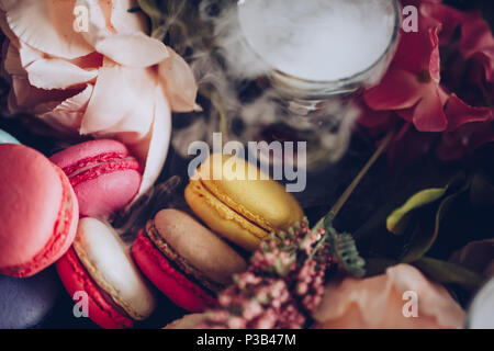 Kuchen Makronen Nebel in den Hintergrund. Close up Macaron Dessert auf der Ansicht von oben. Bunte almond Cookies in Pastell rosa, gelben Farben. Vintage toning Stil. Stockfoto