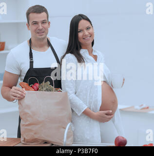 Glückliches Paar neben der Packung, stehen in der Küche. Stockfoto